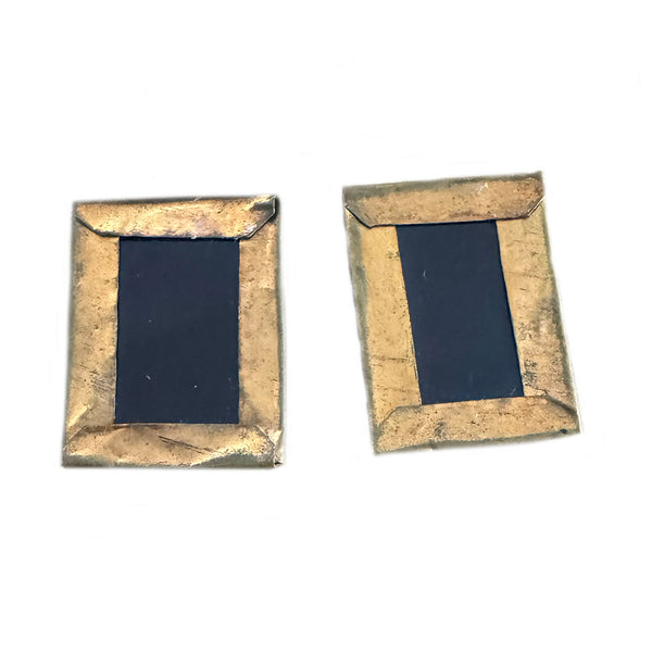 Pair of gold-framed black square earrings on a white background