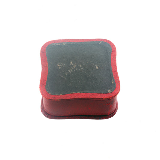 Small rectangular object with red border and grey centre on a white background