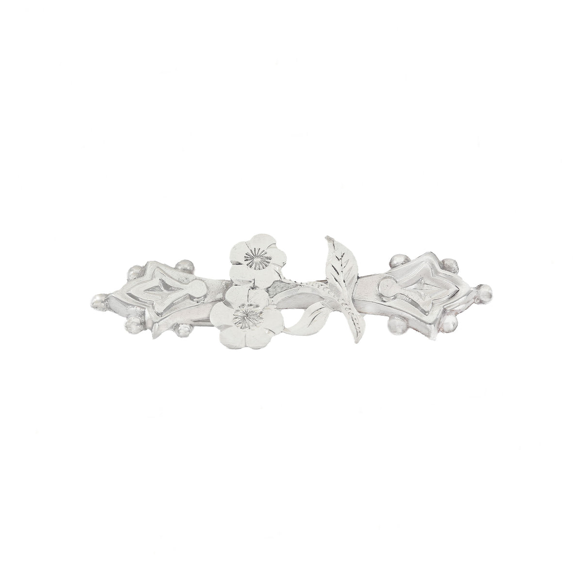 Silver brooch with floral design on a white background