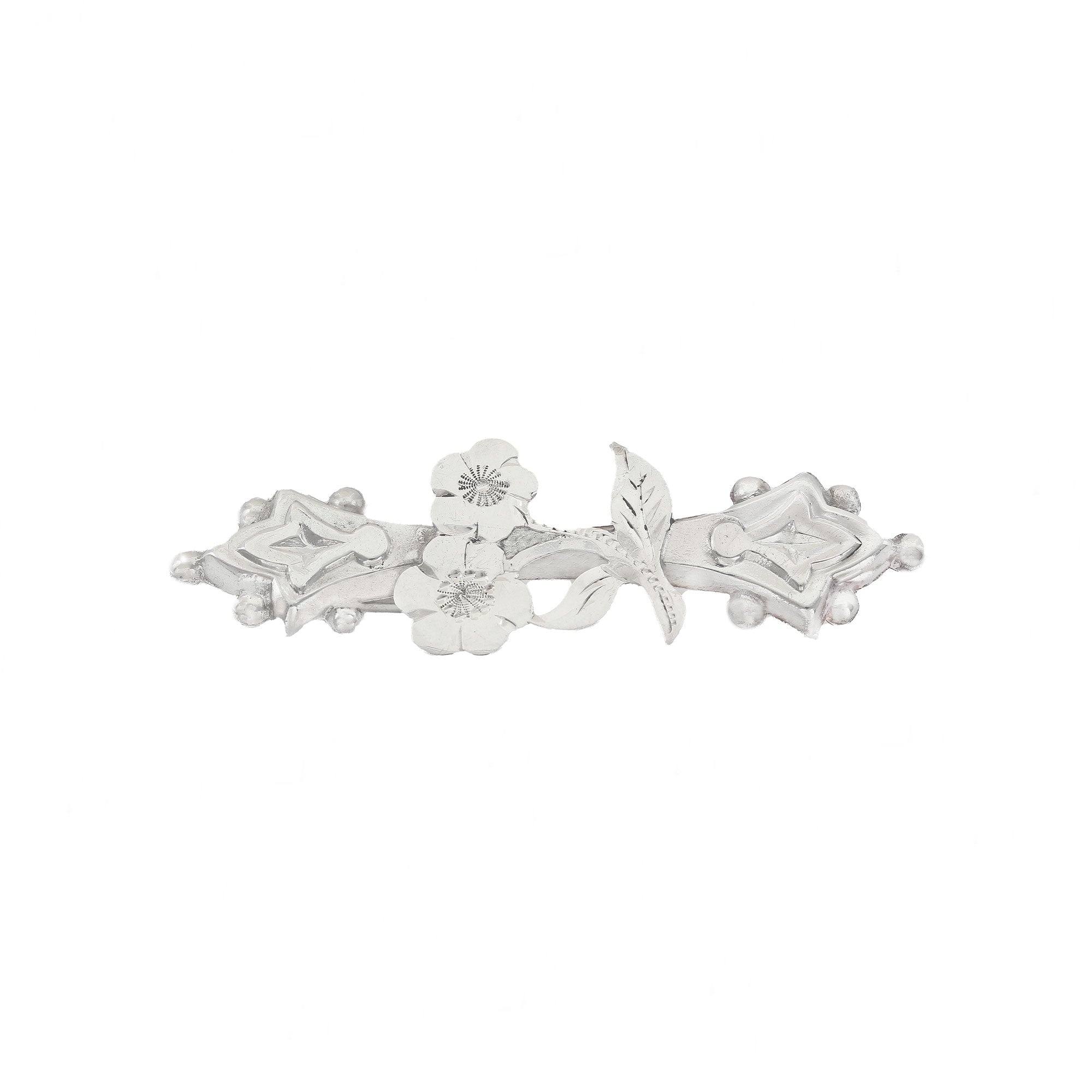 Silver brooch with floral design on a white background