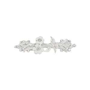 Silver brooch with floral design on a white background