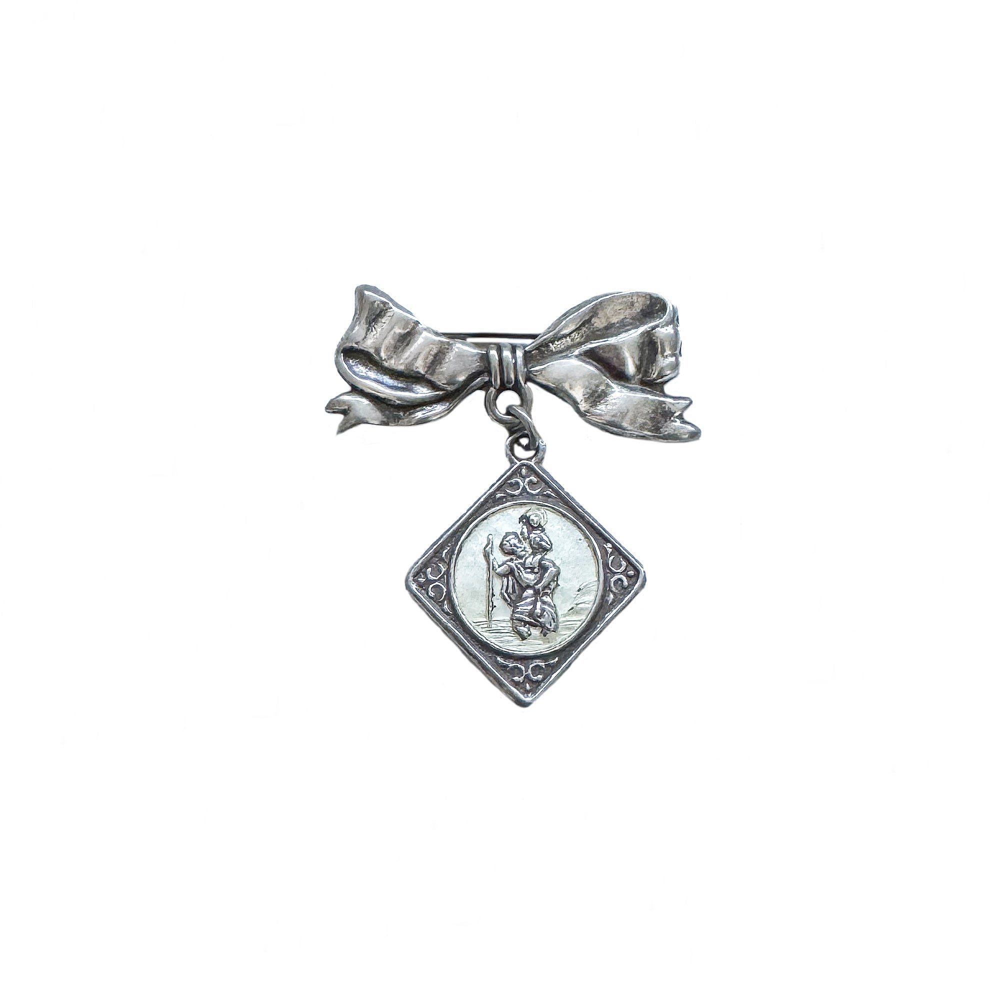 Silver brooch with bow and pendant on a white background