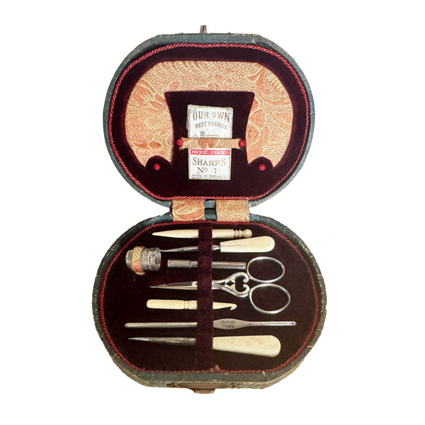 antique sewing kit with tools in an ornate case on a white background