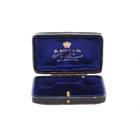 Open jewelry box with blue interior and visible brand name on a white background