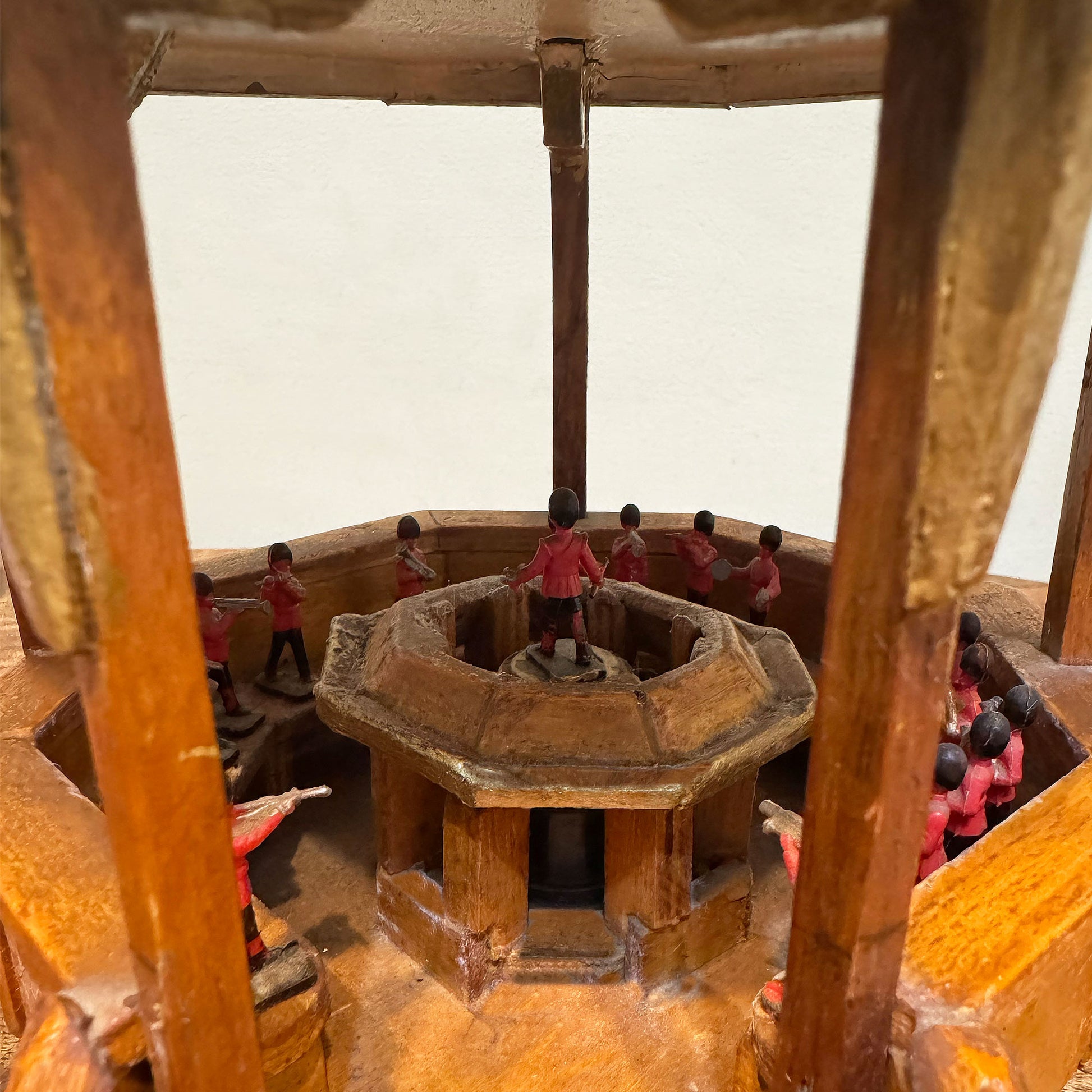 Model of a historical wooden band stand with military playing around it.