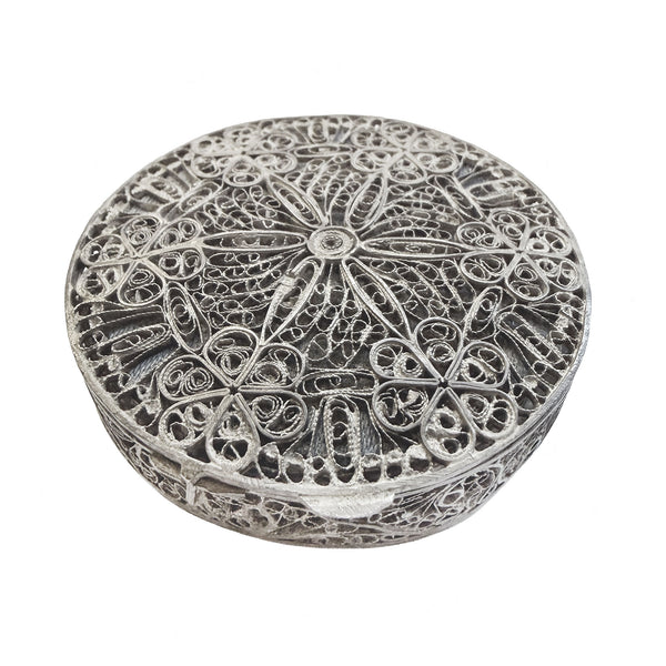 Decorative silver round box with intricate patterns on a white background