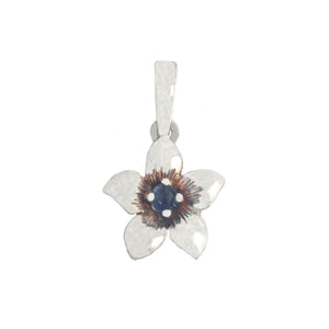 Silver pendant with a floral design and central gemstone on a white background