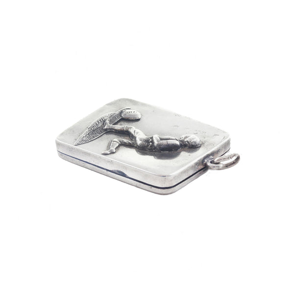 Silver dog tag with a engraved design on a white background