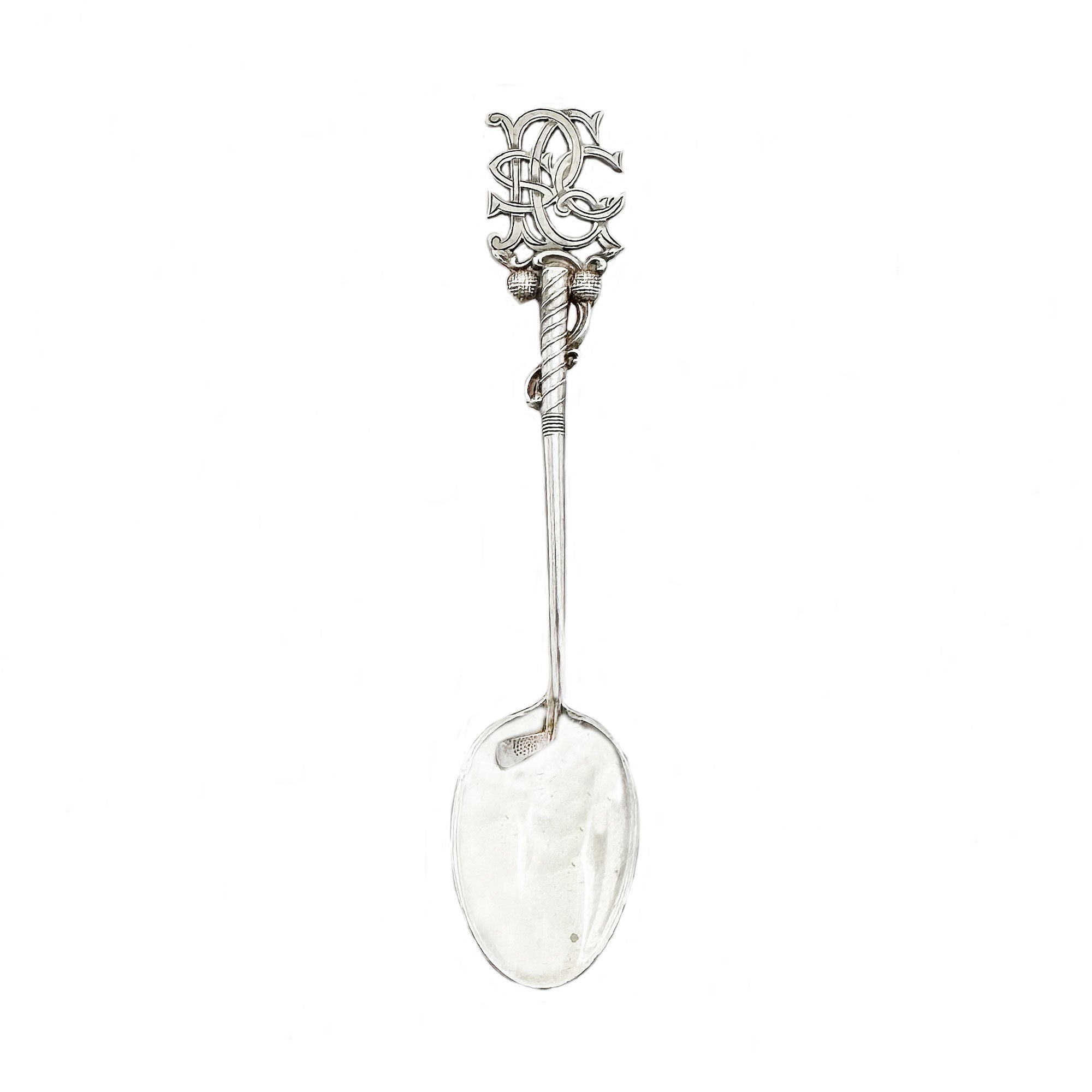 Decorative silver spoon with intricate design on a white background