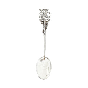Decorative silver spoon with intricate design on a white background