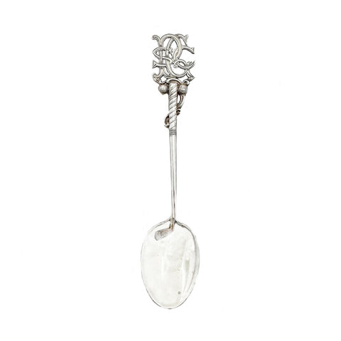 Decorative silver spoon with intricate design on a white background