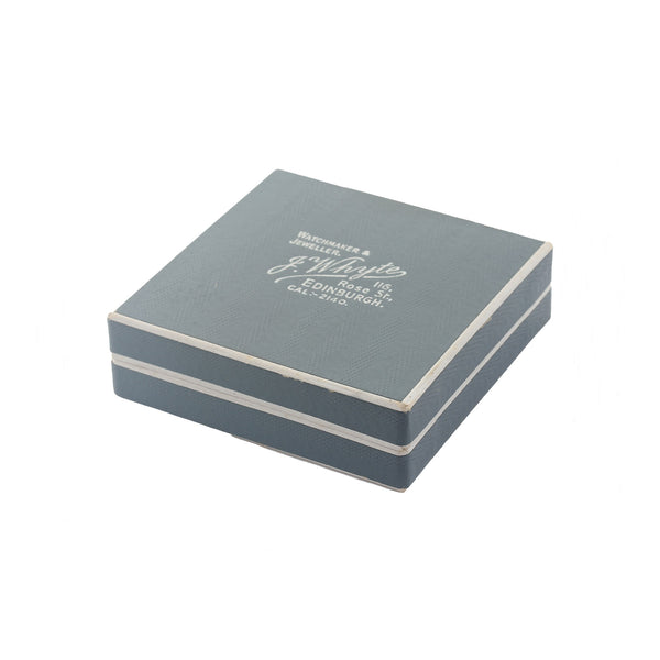 Grey jewelry box with white text on a white background