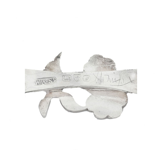 Decorative metal piece with engraved text on a white background
