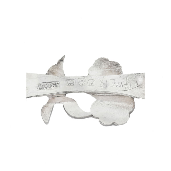 Decorative metal piece with engraved text on a white background