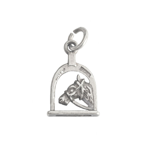 a silver horse stirrup with horse head on a white background