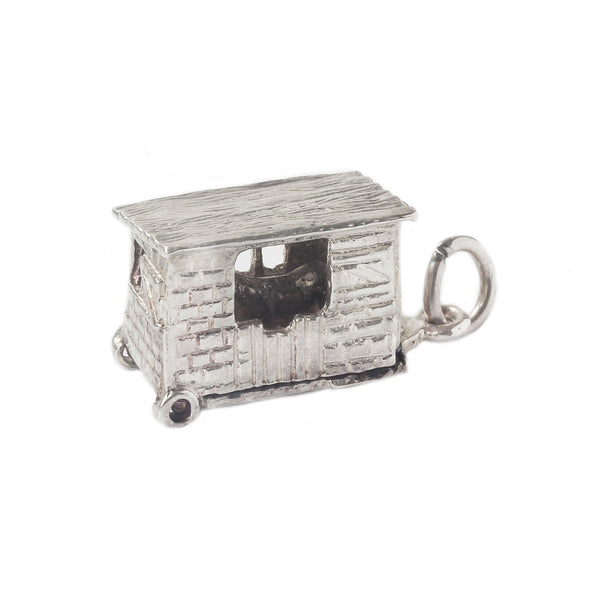 Silver charm shaped like a small house on a white background