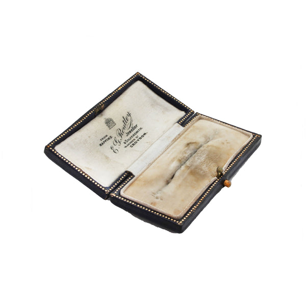 Small leather box with a velvet lining and visible brand name on a white background