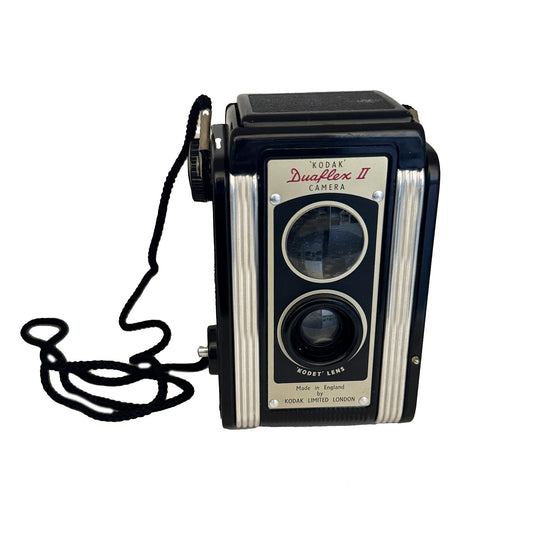 Vintage Kodak Duaflex II camera with a Kodet lens, black color, and a strap attached, against a white background.