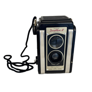 Vintage Kodak Duaflex II camera with a Kodet lens, black color, and a strap attached, against a white background.