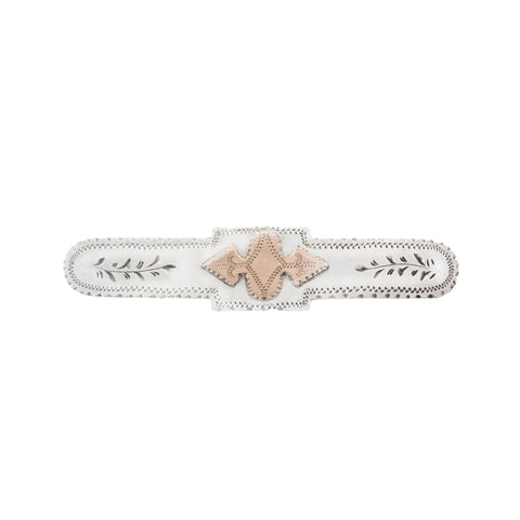 White and beige decorative brooch item with geometric pattern on a white background