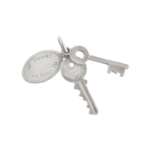 Silver key and round tag charm on a white background