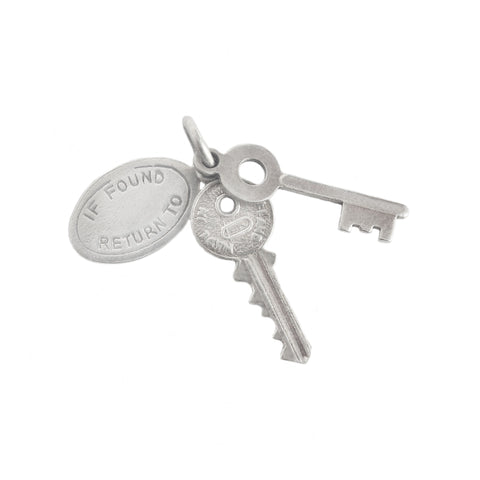 Silver key and round tag charm on a white background