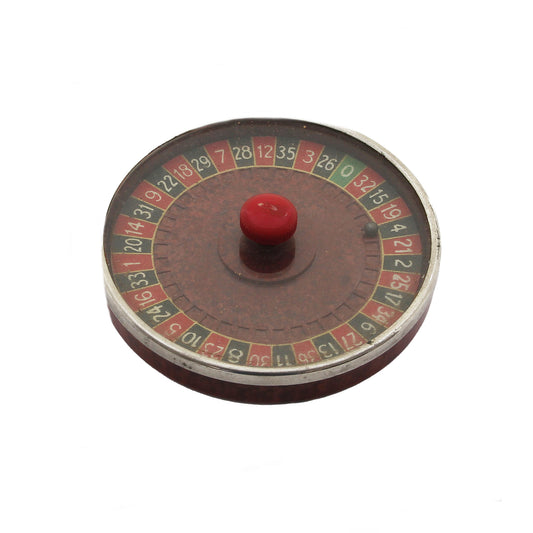 Miniature roulette wheel with red ball on a white background