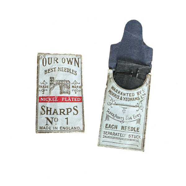 Two vintage needle cases with labels on a white background