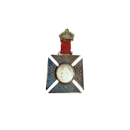 Decorative medal with a central portrait and crown on a white background