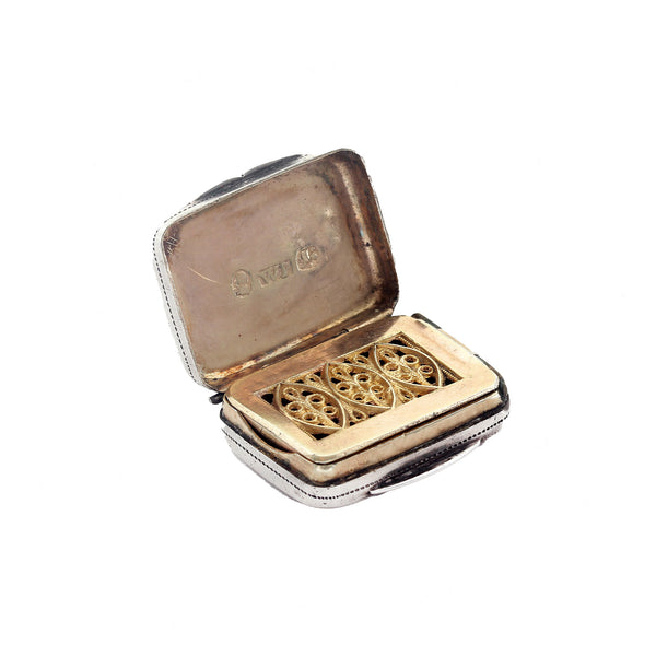 Gold and silver vinaigrette with open lid on a white background