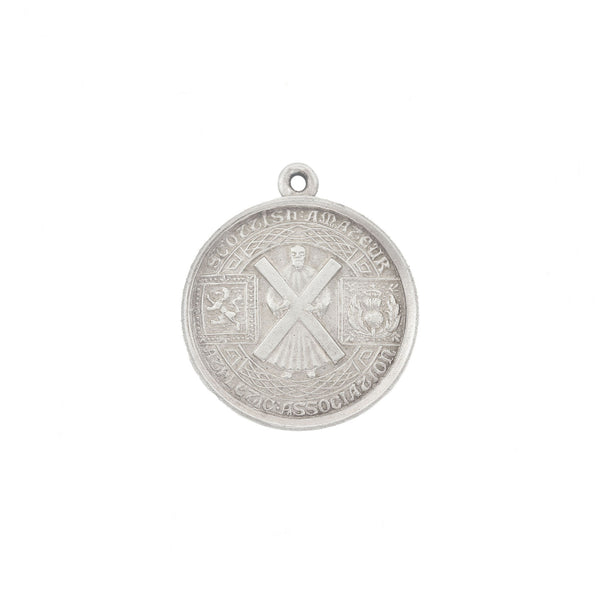 Silver pendant with intricate design on a white background
