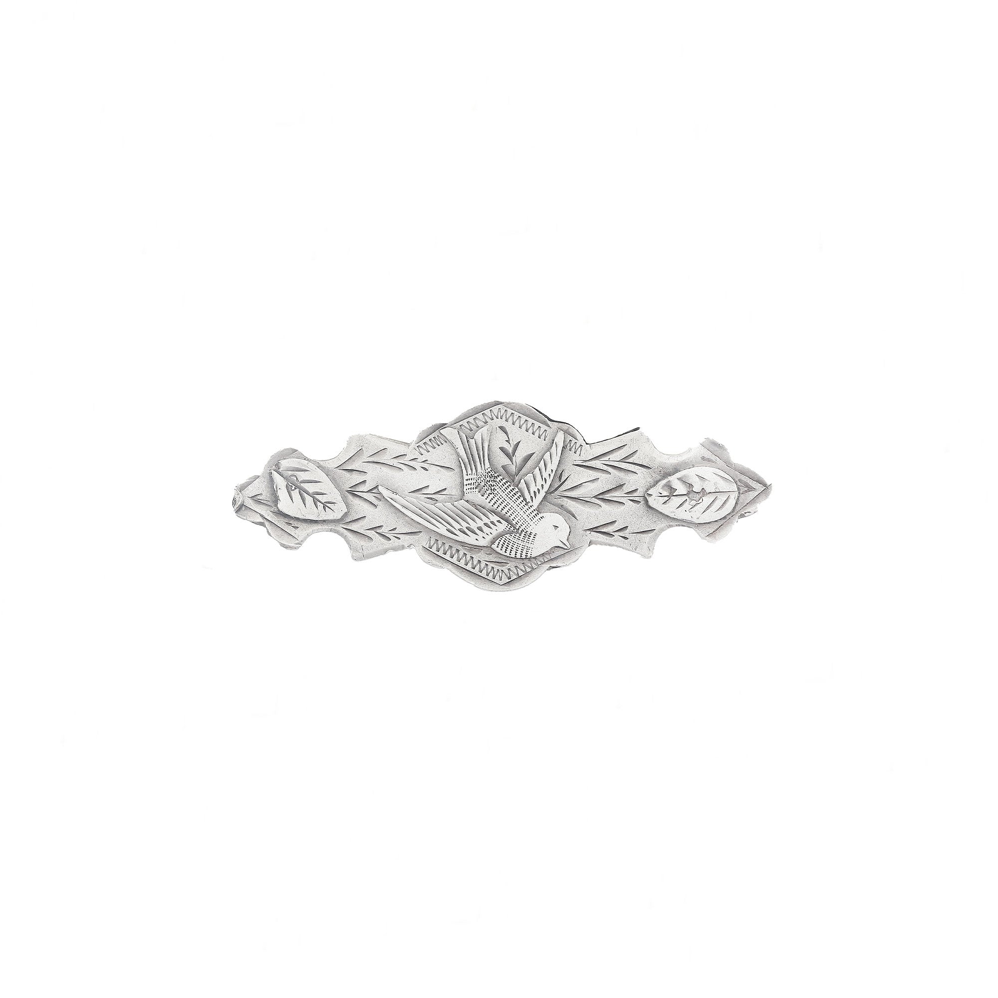 Silver brooch with leaf design on a white background
