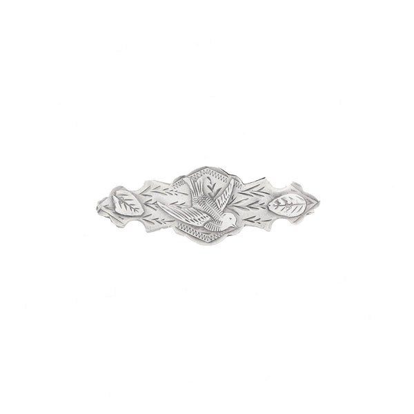 Silver brooch with leaf design on a white background