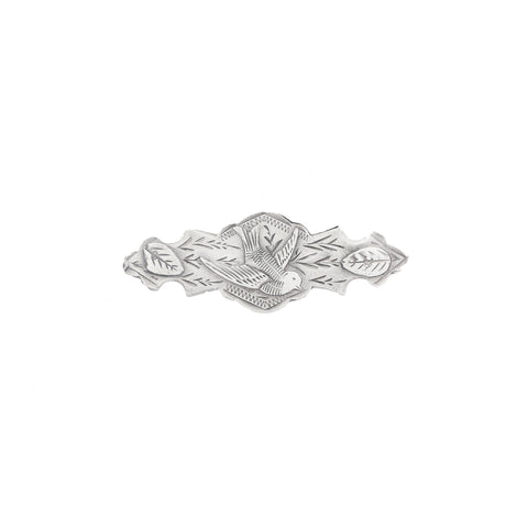 Silver brooch with leaf design on a white background