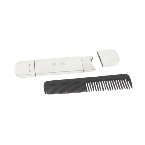 Silver travel case with black comb on a white background