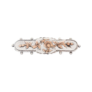 Decorative brooch with floral designs on a white background