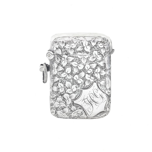 Silver vesta with floral design and 'J' engraving on a white background