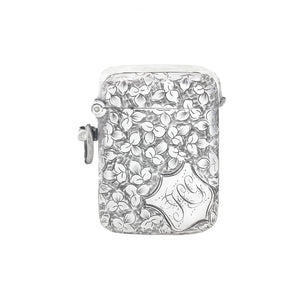 Silver vesta with floral design and 'J' engraving on a white background