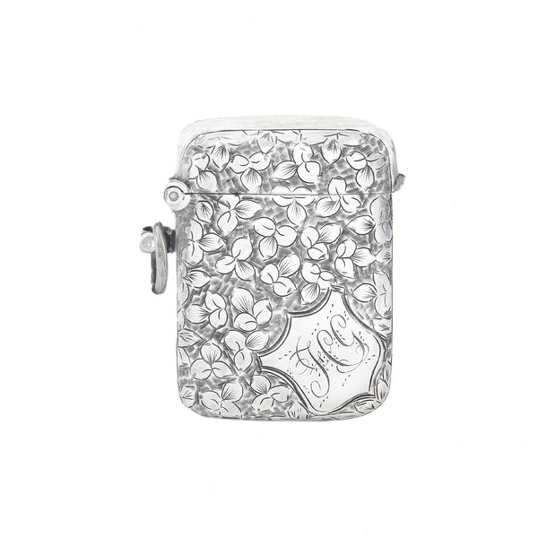 Silver vesta with floral design and 'J' engraving on a white background