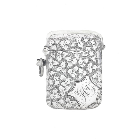 Silver vesta with floral design and 'J' engraving on a white background