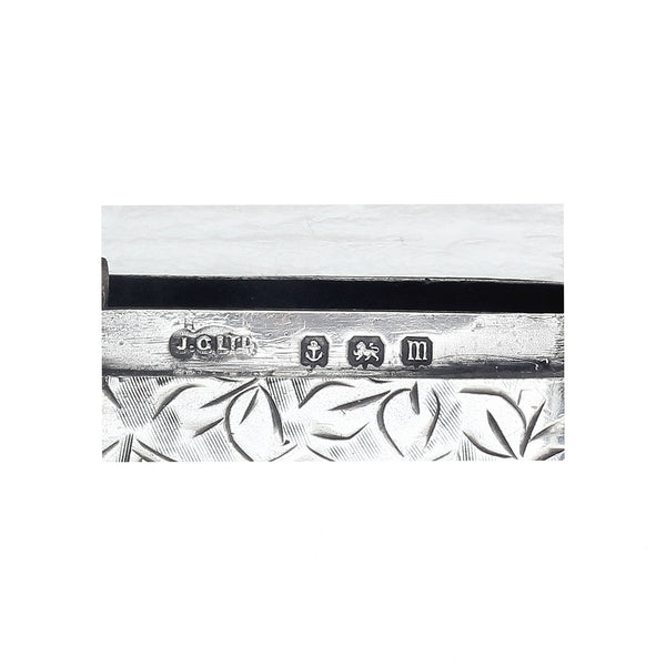 Decorative silver object with engraved design on a white background