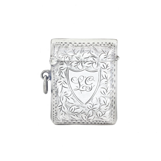 Silver decorative vesta with intricate designs on a white background