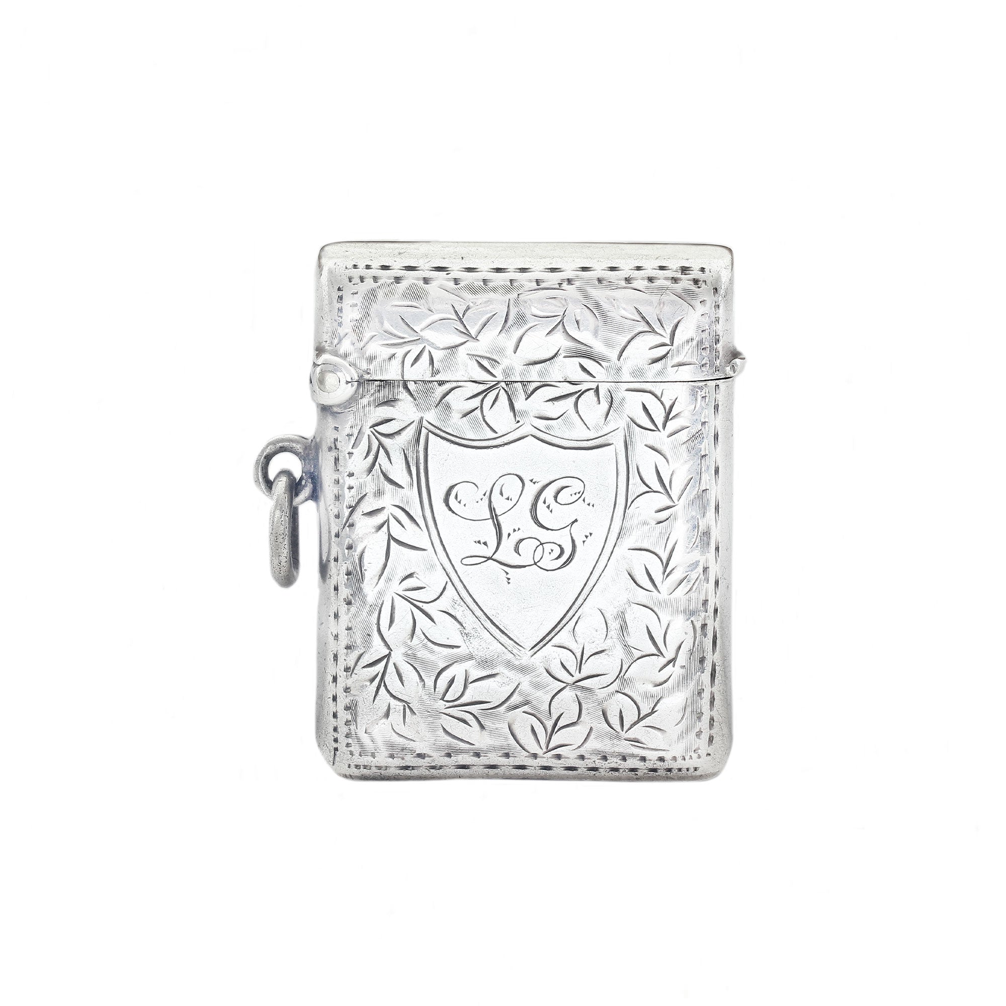 Silver decorative vesta with intricate designs on a white background