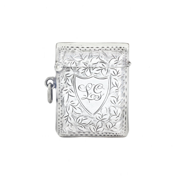 Silver decorative vesta with intricate designs on a white background