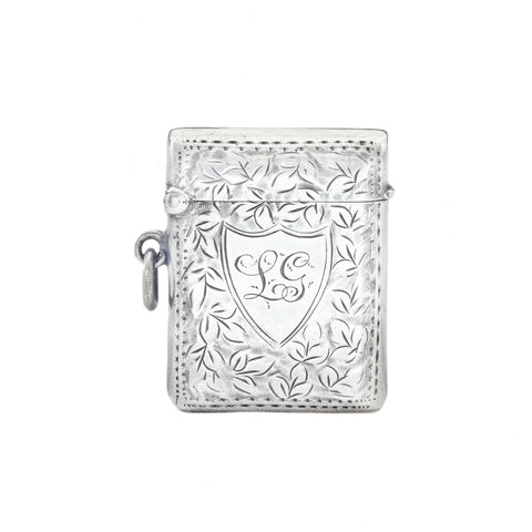 Silver decorative vesta with intricate designs on a white background