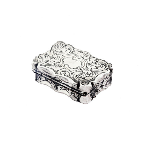 Decorative silver vinaigrette with intricate patterns on a white background