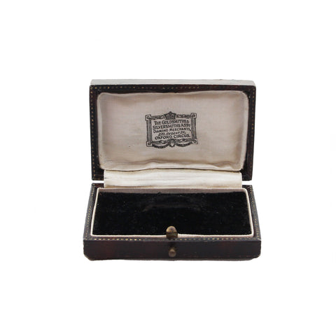 Open jewelry box with velvet interior and visible brand logo on a white background