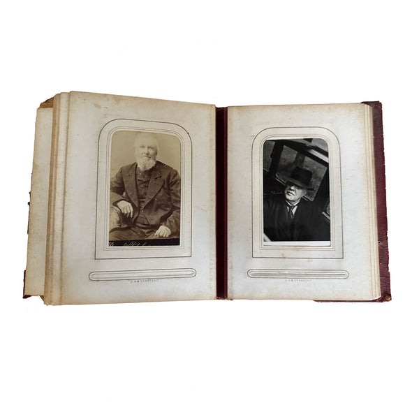 Open photo album with antique portraits on a white background