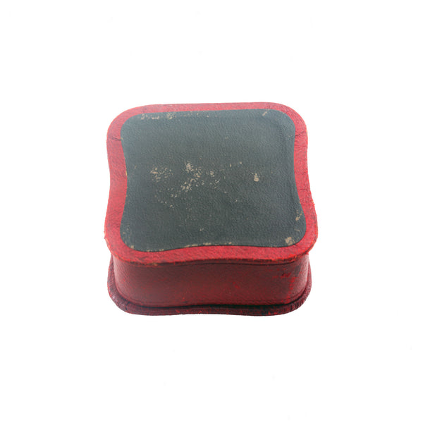 Small rectangular object with red border and grey centre on a white background