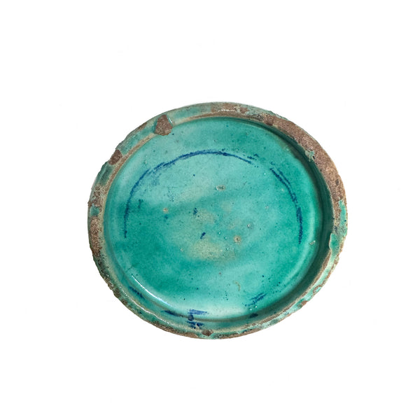 Turquoise ceramic dish with brown rim on a white background